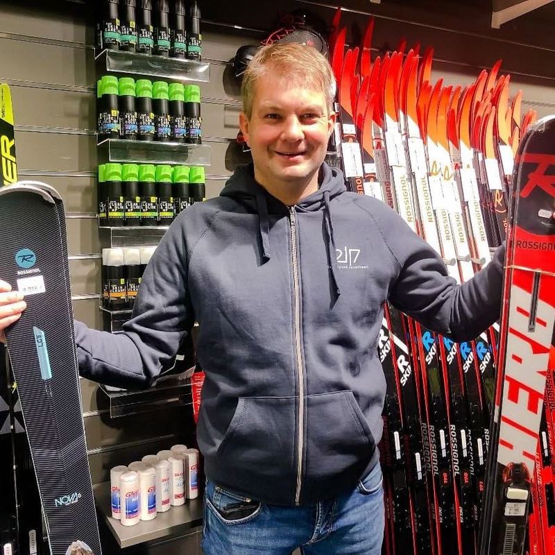 A Trysil Skishop employee in front of the cross-country skis and wax in the shop